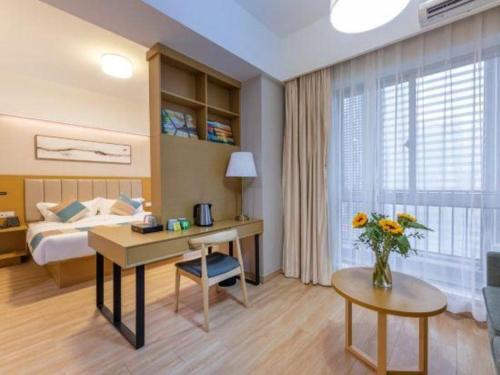 a hotel room with a bed and a desk and a table at VX Hotel Wuxi Xinwu District Executive Center Wanda Plaza in Wuxi