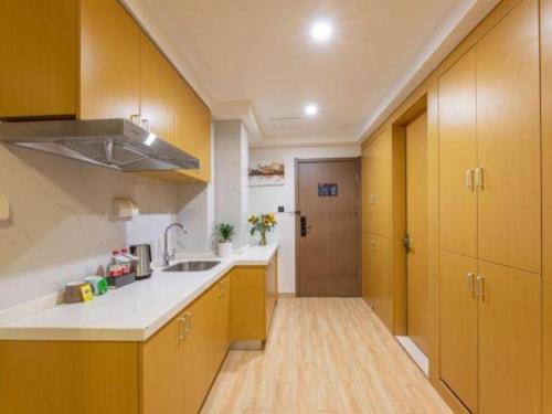 a kitchen with yellow cabinets and white counter tops at VX Hotel Wuxi Xinwu District Executive Center Wanda Plaza in Wuxi