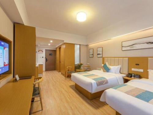 a hotel room with two beds and a flat screen tv at VX Hotel Wuxi Xinwu District Executive Center Wanda Plaza in Wuxi