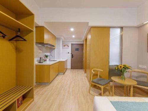 a living room with a table and a kitchen at VX Hotel Wuxi Xinwu District Executive Center Wanda Plaza in Wuxi