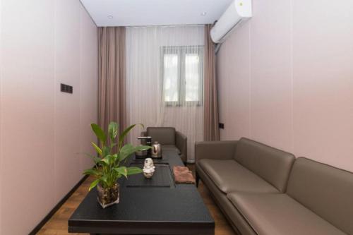 a living room with a couch and a table at Green Tree Inn Express Fuzhou Three Lanes and Seven Alleys Nanmendou Metro Station in Fuzhou