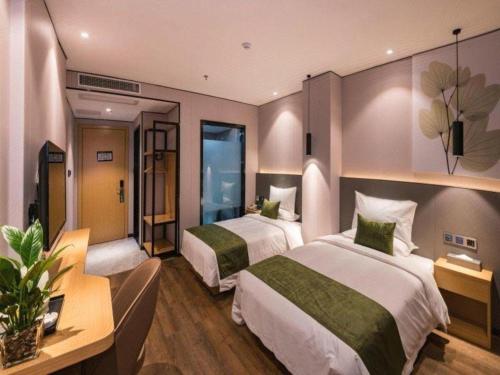 a hotel room with two beds in a room at Green Tree Inn Express Fuzhou Three Lanes and Seven Alleys Nanmendou Metro Station in Fuzhou