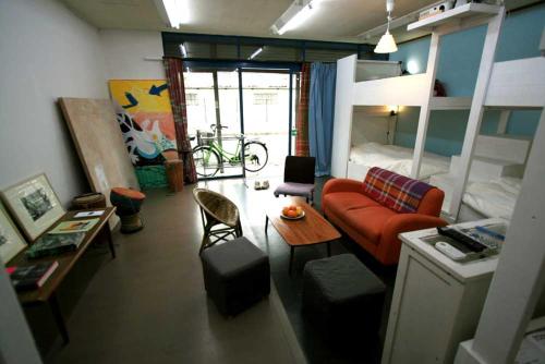 a living room with a couch and a bed at Artist's Studio Kumegawa in Higashi-murayama