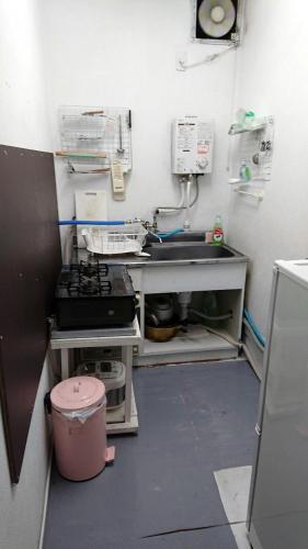 a small kitchen with a sink and a stove at Artist's Studio Kumegawa in Higashi-murayama
