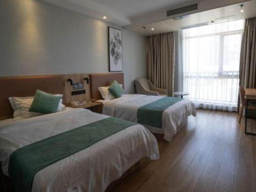 a hotel room with two beds and a window at GreenTree Inn Anqing Yingbin Dong Road High-Speed Railway Station in Anqing