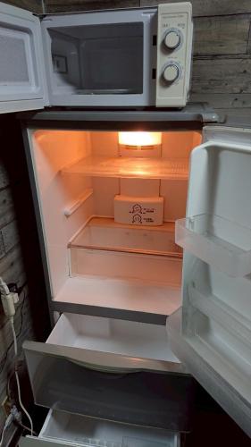 an open refrigerator with a microwave on top of it at Artist's Studio Kumegawa in Higashi-murayama