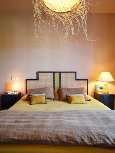 une chambre avec un grand lit avec des oreillers jaunes dans l'établissement Family Home Between Forest And Ocean In Mimizan, à Mimizan