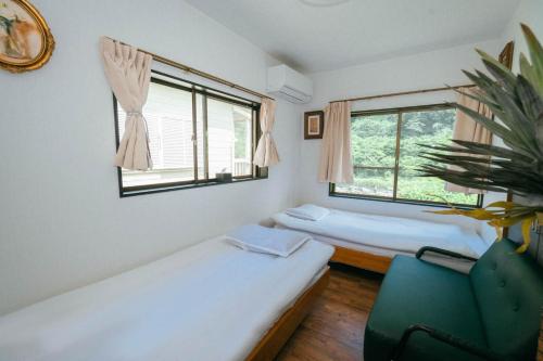 a room with two beds and a chair and a window at 山崎公園-箱根湯本駅-最大8名 in Hakone