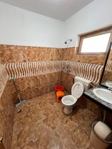 a bathroom with a toilet and a sink at Sky Land guest house in Leh