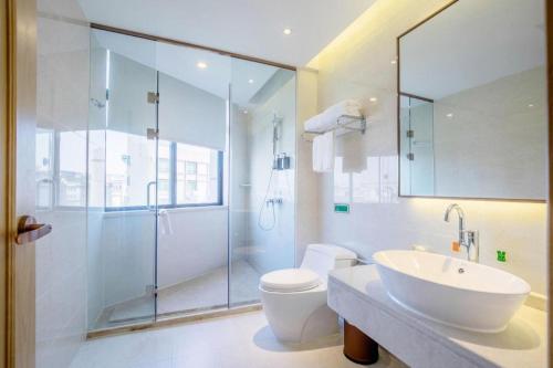 a bathroom with a toilet and a sink and a shower at Vienna Hotel Guangdong Zhongshan Xiaolan High-Speed Railway Station in Zhongshan