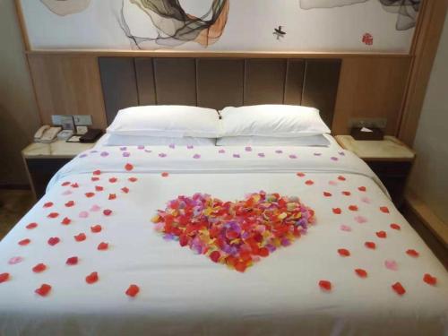 a heart made out of flowers on a bed at Venus Royal Hotel Nanning East High-Speed Railway Station in Nanning