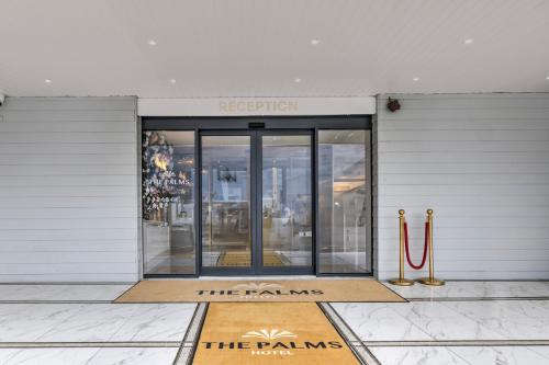 an entrance to a building with a sign that reads the palms at Palms Hotel & Retreat By Palette London Romford in Hornchurch