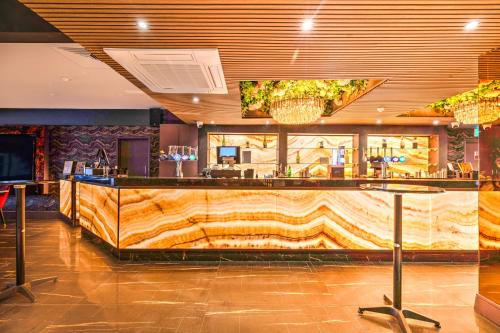 a bar in a restaurant with a wooden counter at Palms Hotel & Retreat By Palette London Romford in Hornchurch