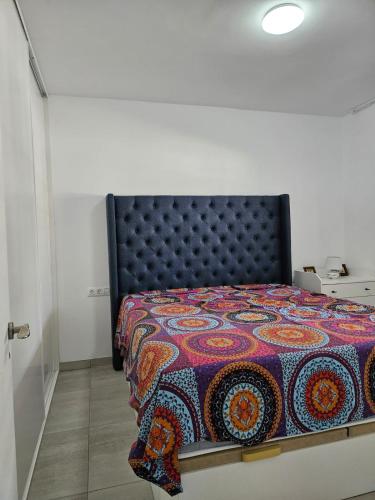 a bedroom with a bed with a colorful quilt at Apartment mit Poolsicht in Costa Del Silencio