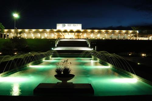 a building lit up at night with a fountain at Howard Johnson Sierras Hotel y Casino Alta Gracia in Alta Gracia