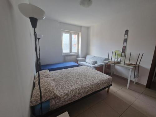 Un dormitorio con una cama, una silla y una lámpara. en Bnb Petrarca, en Sesto San Giovanni