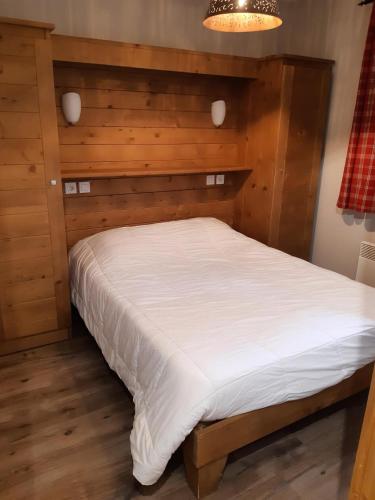 - un lit dans une chambre avec une tête de lit en bois dans l'établissement Résidence Le Chalet des Rennes - maeva Home - Appartement 2 pièces 4 personnes - Sélection MAE-4224, à Vars