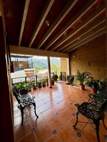 a patio with two chairs and a balcony with plants at Hospedaje Teponaztle in Tepoztlán
