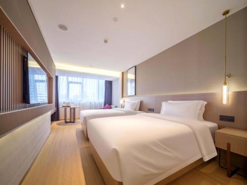 two large white beds in a hotel room at Lavande Hotel Guangzhou Quzhuang Metro Station in Guangzhou
