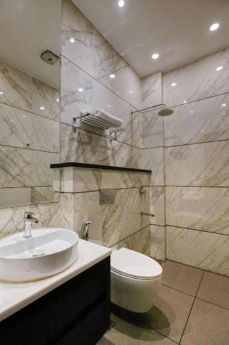 a bathroom with a sink and a toilet at Royal escape in Gurgaon