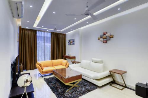a living room with a couch and a table at Royal escape in Gurgaon