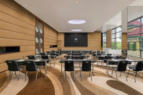 a conference room with tables and chairs and a screen at W Bangkok Hotel in Bangkok