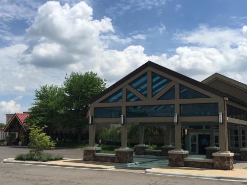 a large building with glass windows in a parking lot at The Kensington Hotel in Ann Arbor
