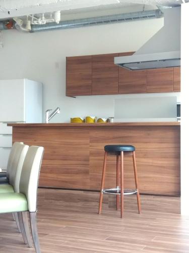 a kitchen with a stool in front of a counter at キュリナリーBed and Art in Hamamatsu