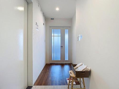 a hallway with a door and a chair in a room at キュリナリーBed and Art in Hamamatsu