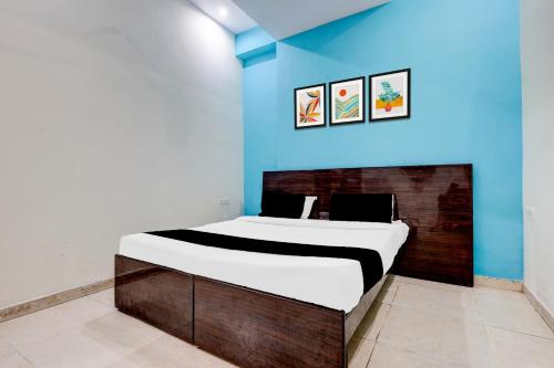 Bett in einem Zimmer mit blauer Wand in der Unterkunft Hotel O Katla Bazar Near Rewari Junction in Rewāri