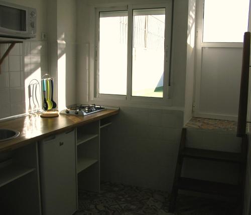 a kitchen with a counter and a window and a sink at Apartamentos Calypso in Punta Umbría