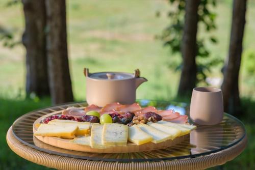a plate of cheese and fruit on a table at Mountain harmony Lovćen in Cetinje