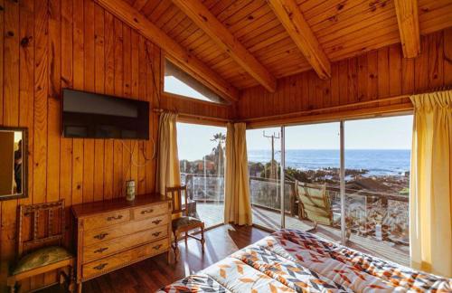 a bedroom with a bed and a view of the ocean at Cabañas Niki Familiar in Maitencillo