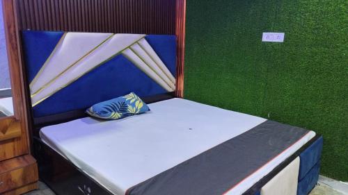 a small bed in a room with a green wall at Dream Inn in Delhi