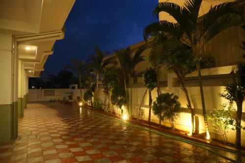 a building with a courtyard with palm trees at night at Hotel Vistaara Grand in Guntūr