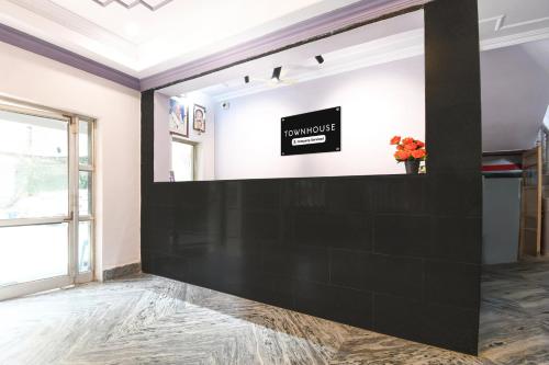 a large black wall in a room with a mirror at Super Townhouse Jyoti Mahal Road Rayagada in Rāyagada