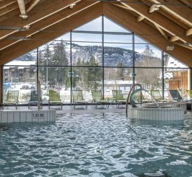 - une grande piscine d'eau dans un bâtiment avec fenêtres dans l'établissement Cozy apartment, à Arâches-la-Frasse
