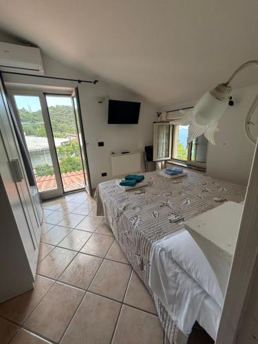 a bedroom with a white bed and a television at Villa Alessandra in Maratea