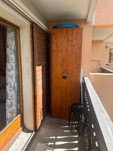 a hallway with a wooden door and two chairs at Cozy apartment in Arâches-la-Frasse