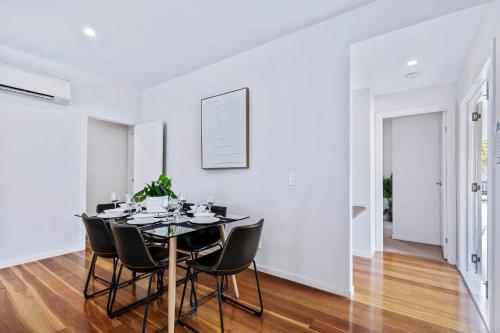 a white dining room with a table and chairs at Park Avenue Terrace House 3BR - Outdoor, BBQ in Brisbane