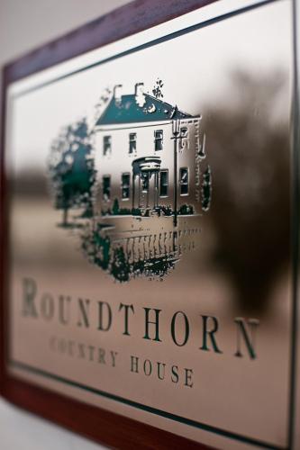 a picture of a white house in a frame at Roundthorn Country House & Luxury Apartments in Penrith