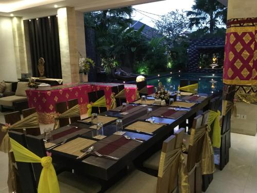 ein Esszimmer mit einem langen Tisch in einem Restaurant in der Unterkunft The Amarta Villa in Jimbaran