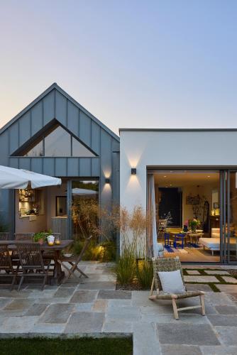 une maison avec un patio avec une table et des chaises dans l'établissement Superbe villa 5 étoiles, piscine intérieure chauffée 29C, à Combrit