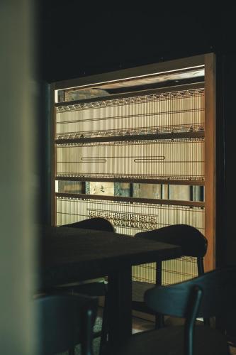 a table and chairs in front of a window at ame nakasendo - A 150 years old private kominka along the Nakasendo trail - in Nagiso