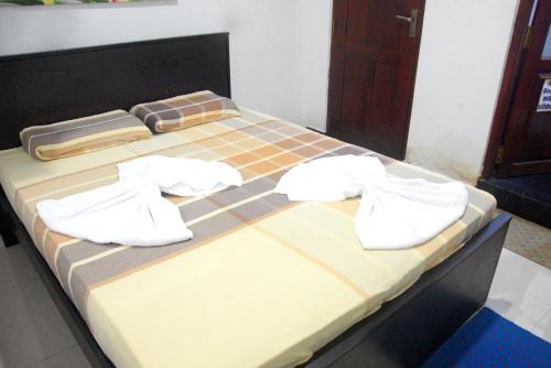a bed with white towels on top of it at Swiss Grand Lanka in Homagama