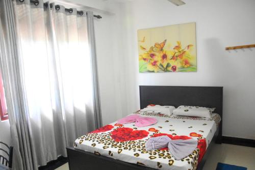 a bedroom with a bed with flowers on it at Swiss Grand Lanka in Homagama