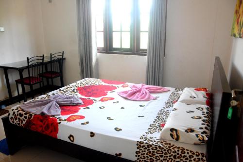 a bedroom with a bed with flowers on it at Swiss Grand Lanka in Homagama