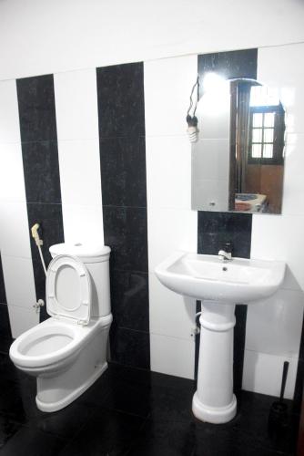 a bathroom with a toilet and a sink at Swiss Grand Lanka in Homagama