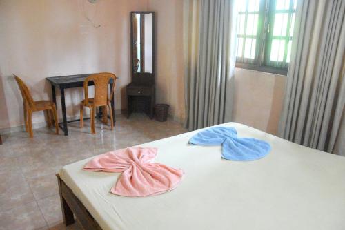 a room with a bed with two towels on it at Swiss Grand Lanka in Homagama