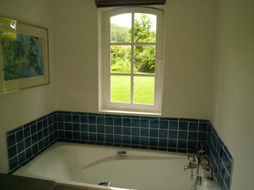 a bath tub in a bathroom with a window at La Bonne Auberge - Seine Panorama SAS in Vieux-Port